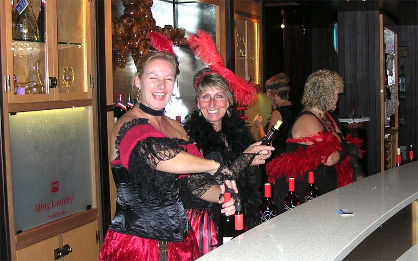 A woman in a red dress is holding a bottle of wine