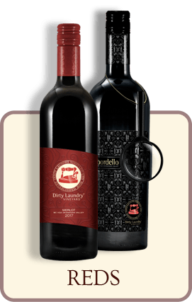 Two bottles of red wine are sitting next to each other on a table.
