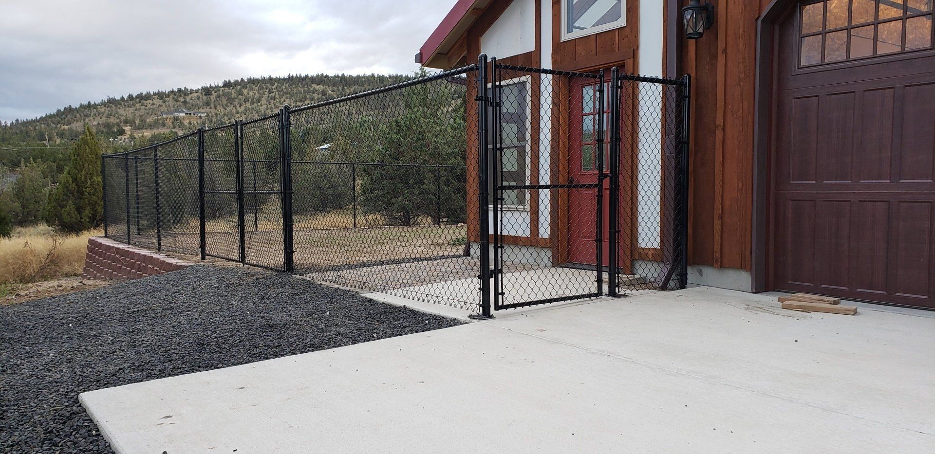Picture of a tall chain link fence surrounding an agricultural building by a Madras fence contractor.