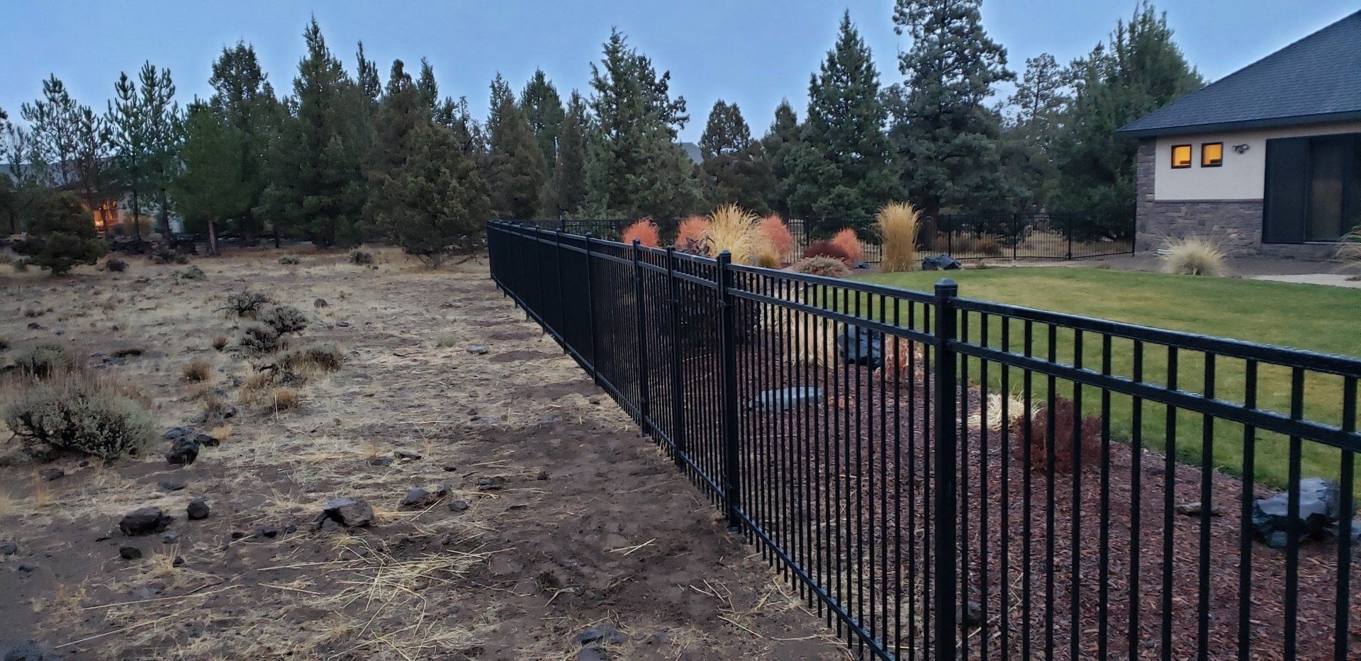 Black metal fence installed along rural dirt property line
