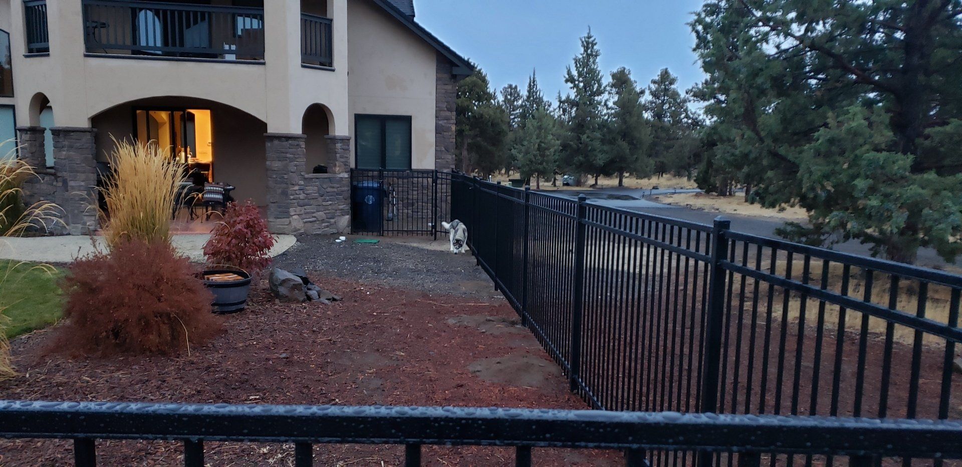 Black metal fence installed along landscaped yard with pathway