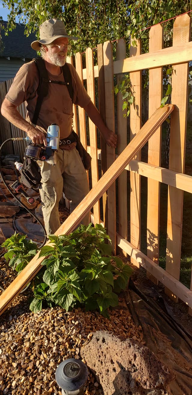 Photo of the owner, Peter Rowe, outside working on a fence.