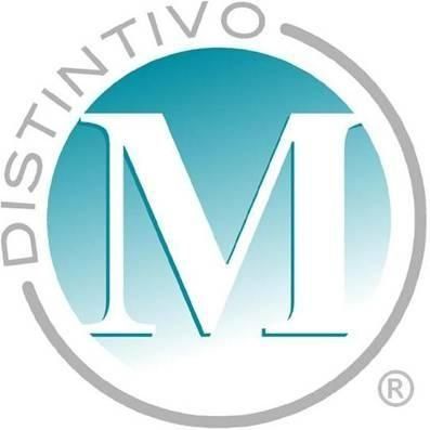 Logotipo de Distintivo con una gran M blanca en un círculo verde azulado, rodeado por un anillo gris y texto.
