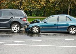 two cars are involved in a car accident on the side of the road . body shop suffolk county