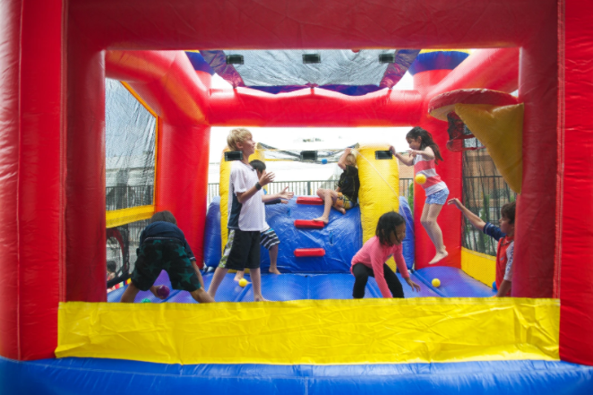 A group of children are playing in a bouncy house.