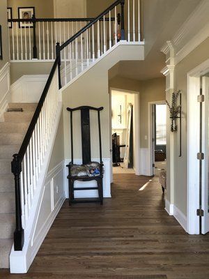 Bright foyer with staircase, wood floors, and a bench against the wall