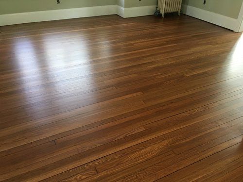 Empty room with polished hardwood floor and light green walls