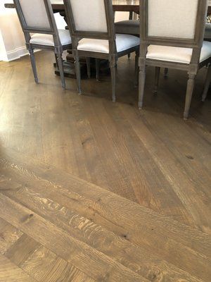 Wooden dining room floor with a row of upholstered chairs along the wall