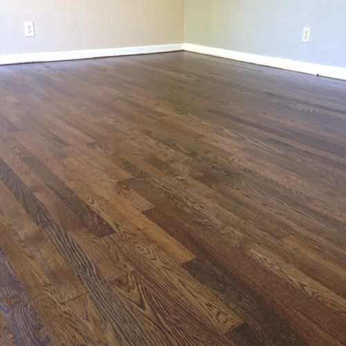 Empty room with dark wood flooring and light beige walls