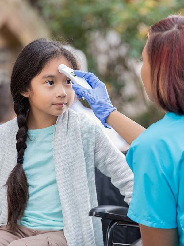 Nurse taking child's temperature