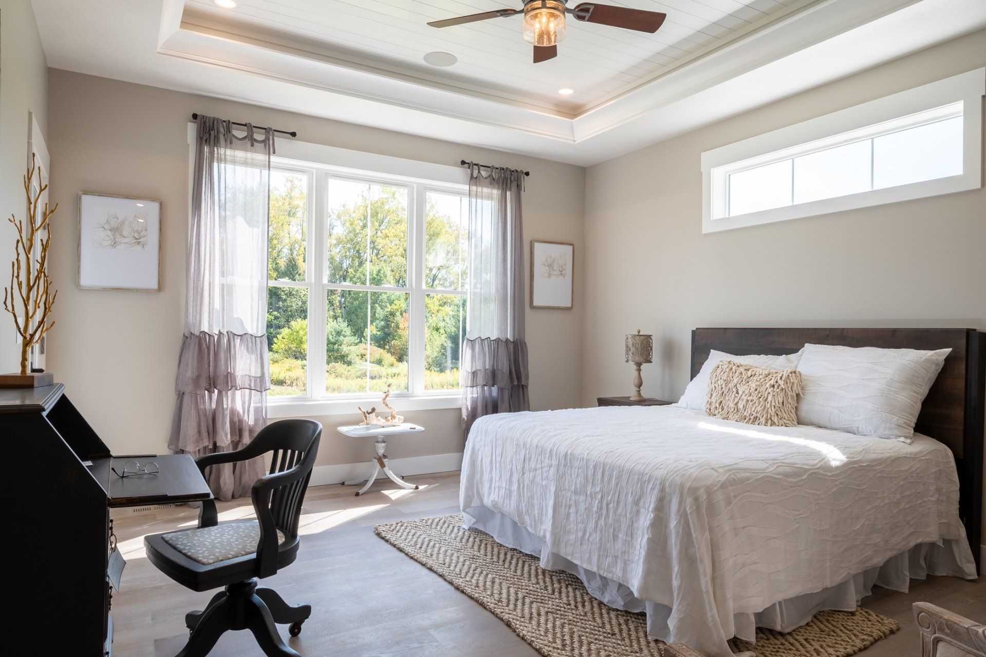 primary bedroom with recessed ceilings and ceiling fan