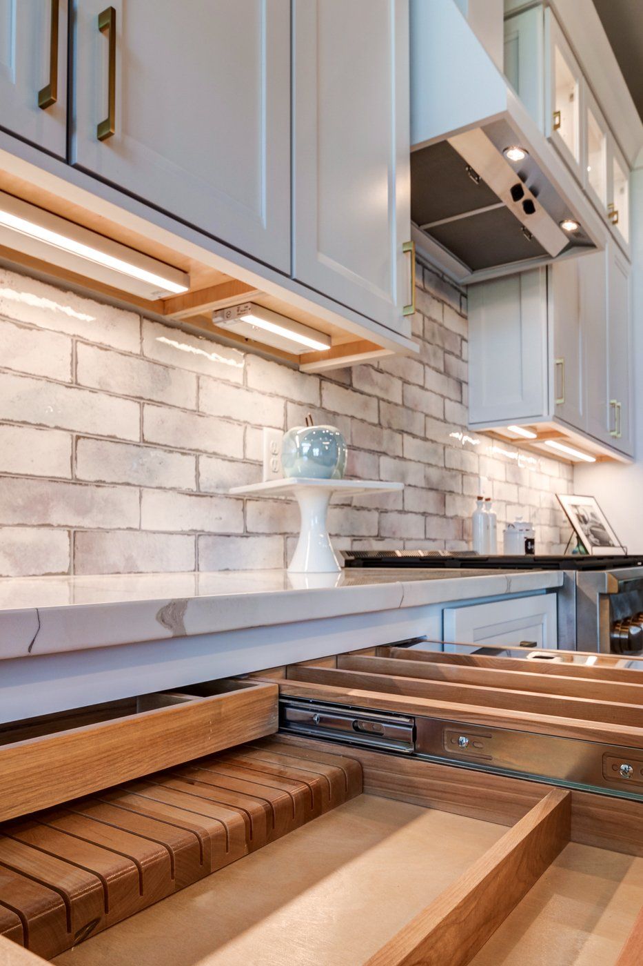 brick backsplash and drawers with organizers