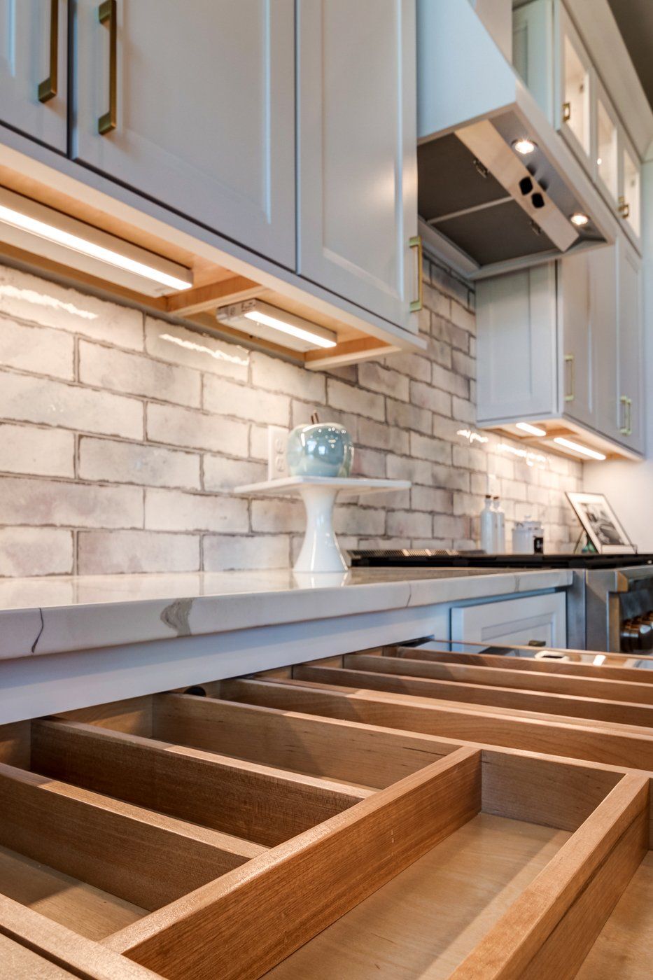 brick backsplash and drawers with orgainzers
