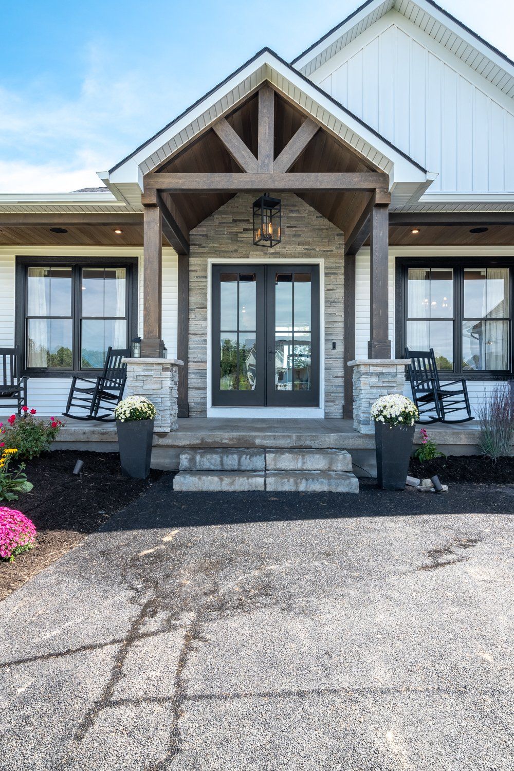 driveway and covered front porch with rocking chairs