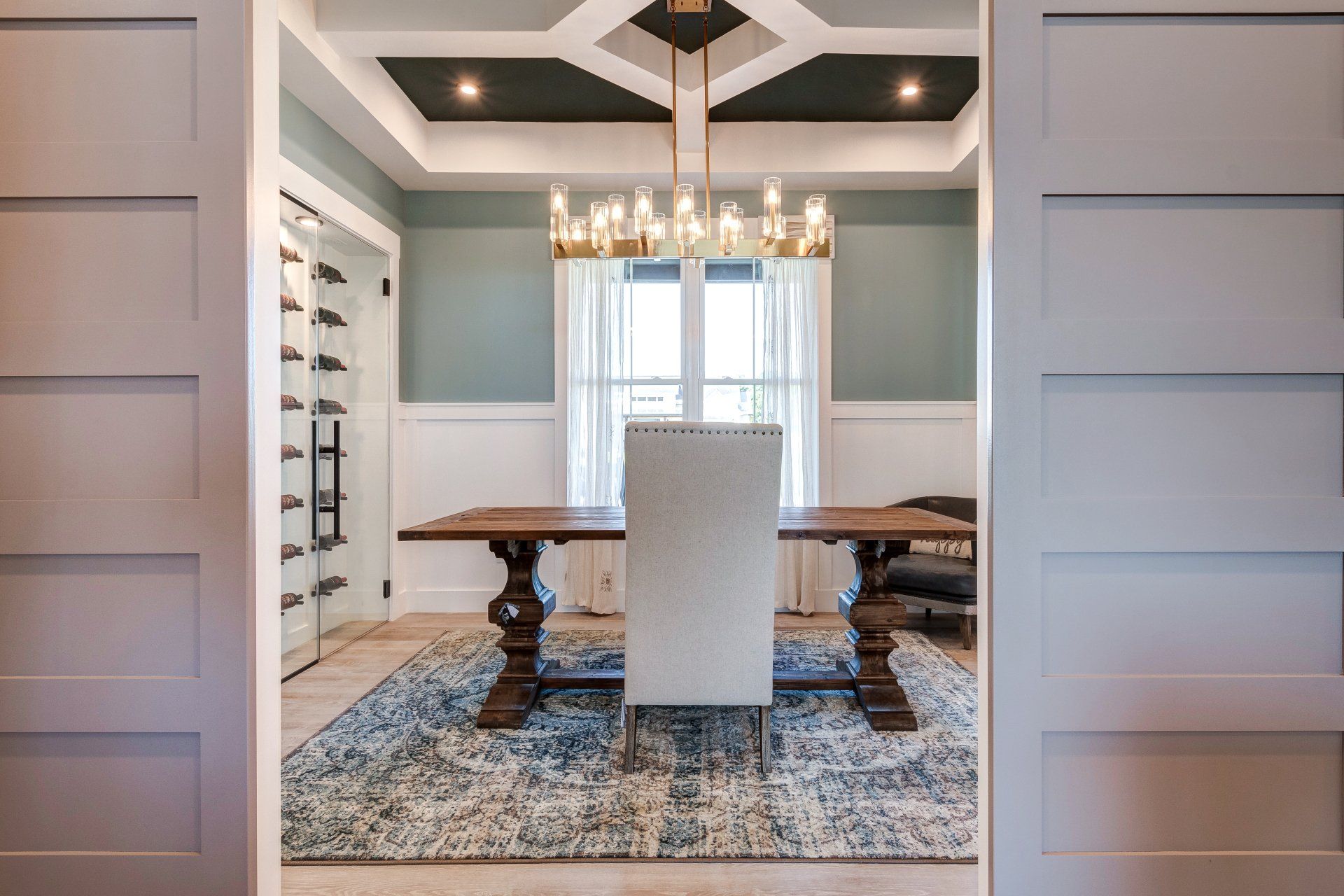 Dining room with glass wine cellar, table with 2 seats, and chandelier