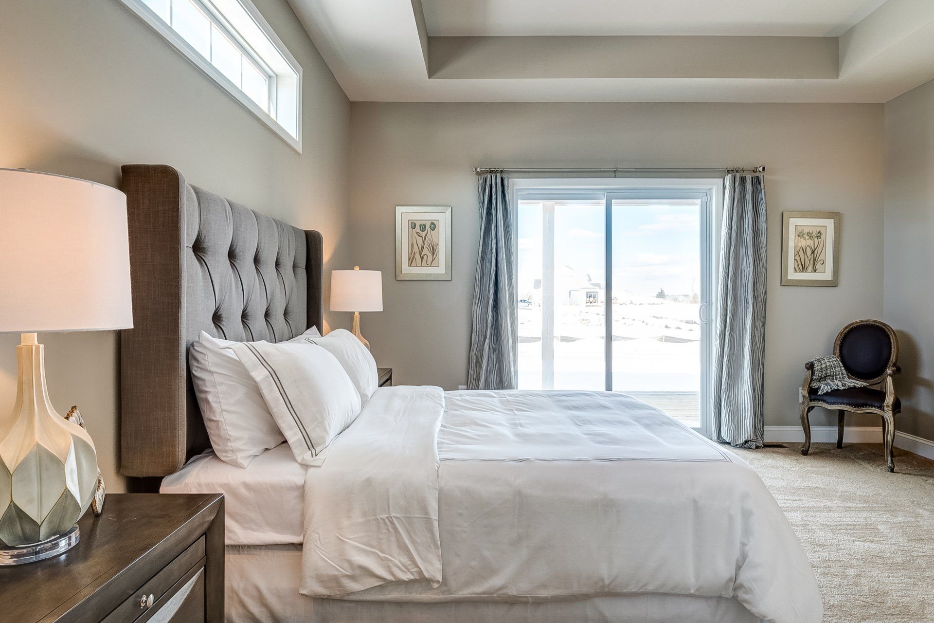 primary bedroom with recessed ceiling and door to backyard