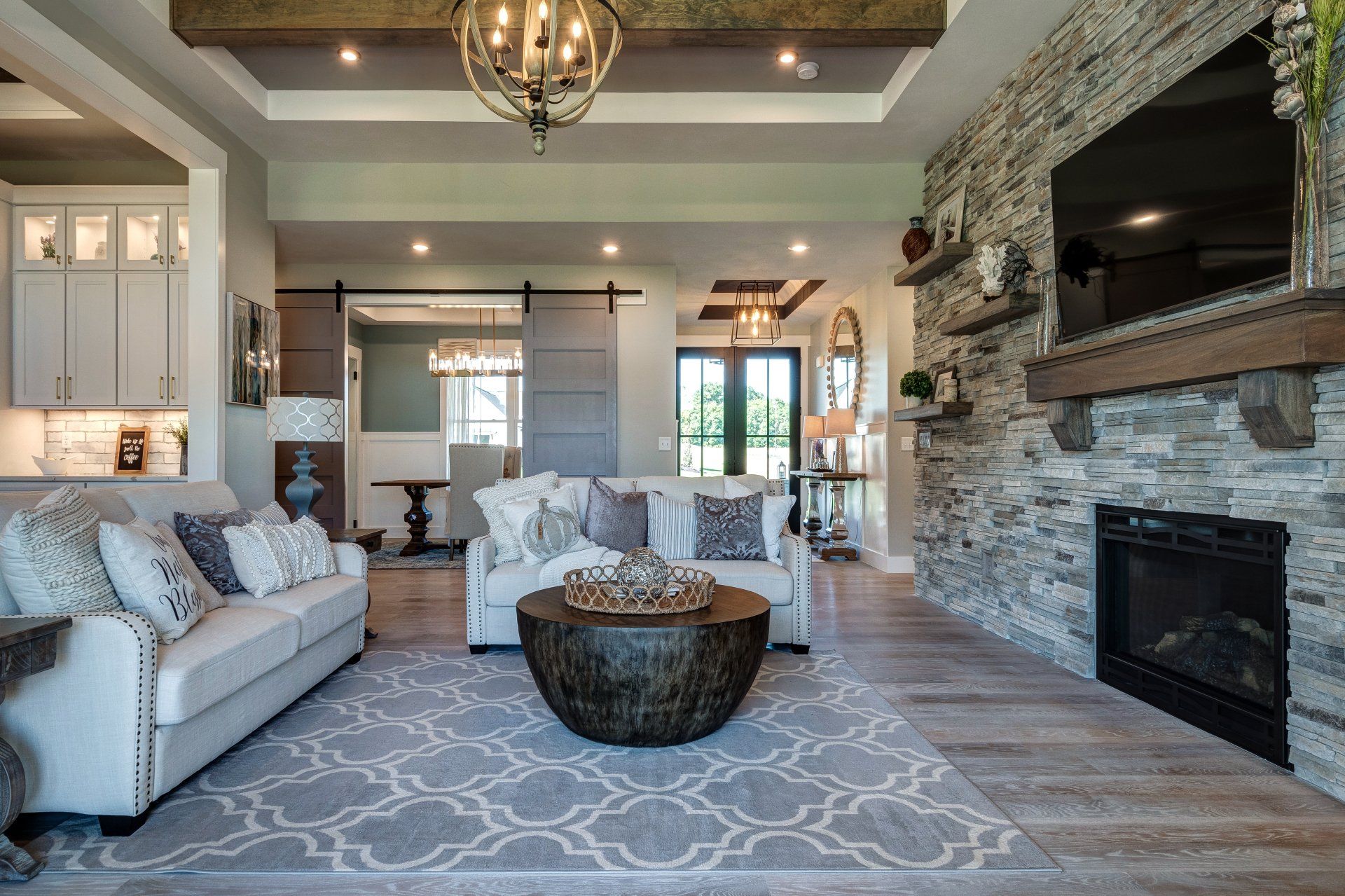 Living room with stone wall, fireplace, and recessed ceilings