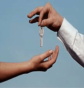 Two hands exchanging a silver key against a blue background
