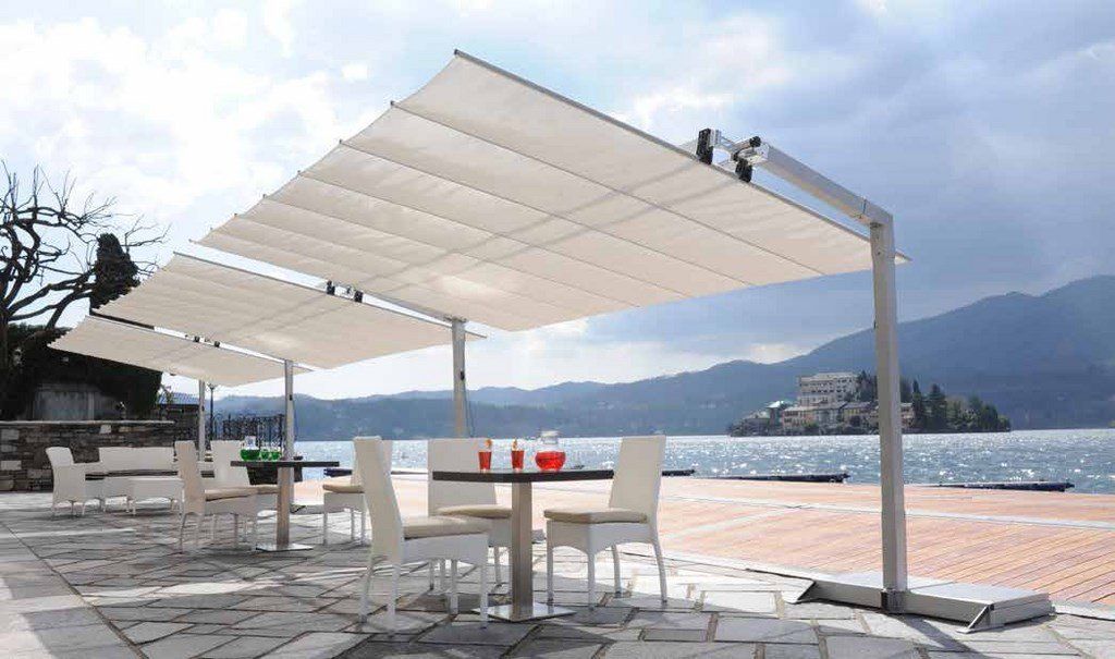 Gazebo moderno sopra tavolini vicino al mare
