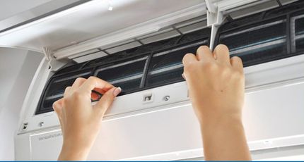 hands fixing AC