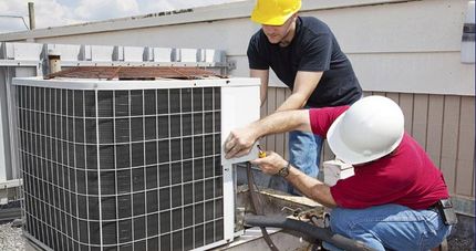 two men fixing an air condition