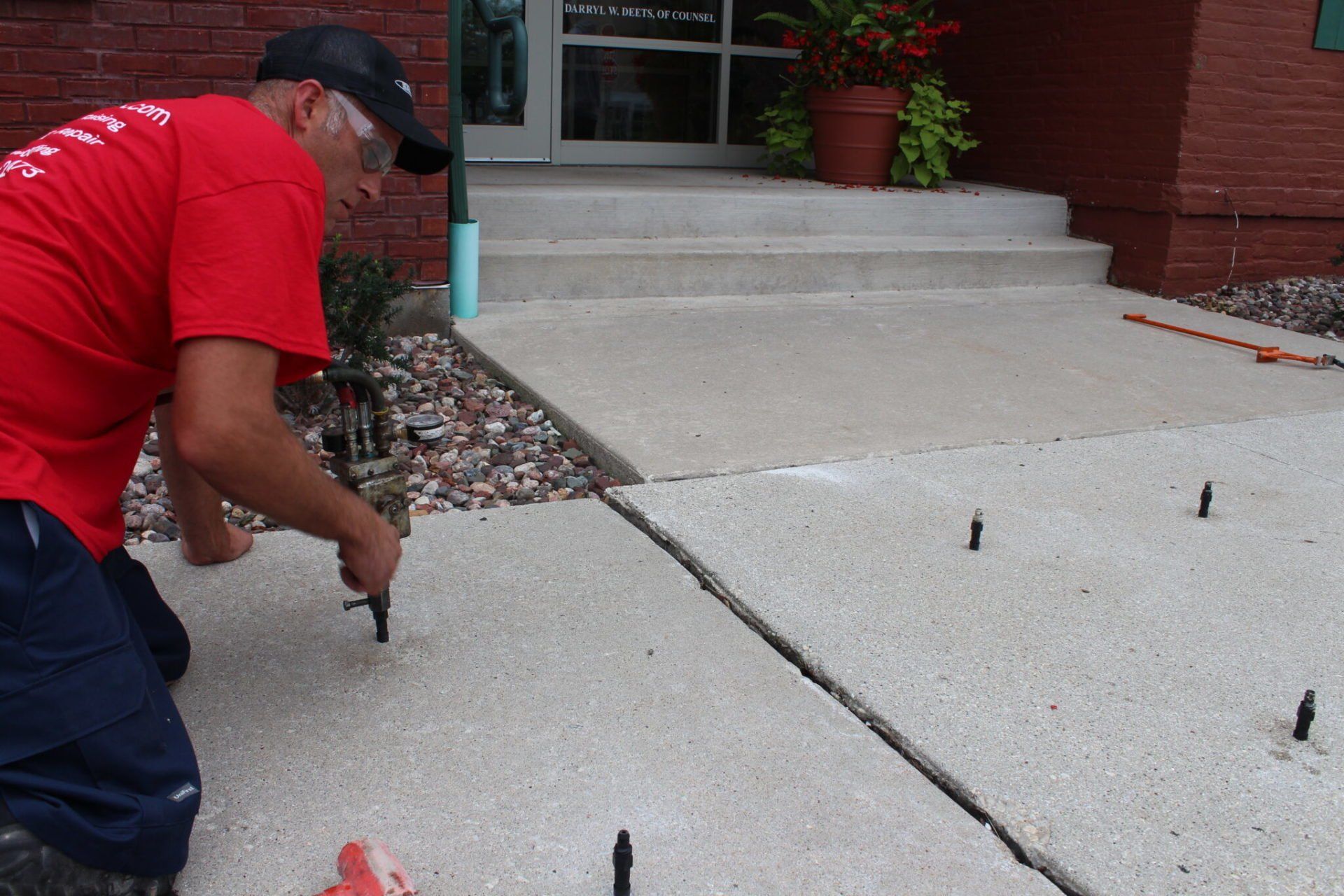 A concrete technician is applying the chemical compound to a residential slab.