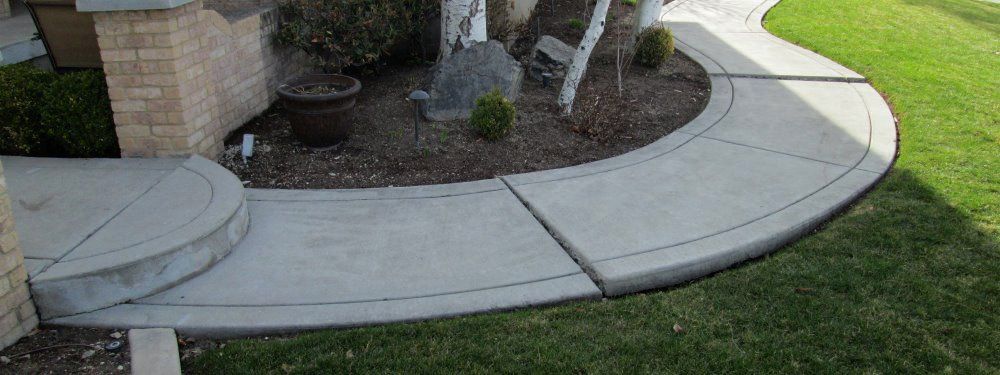 A concrete walkway with steps leading to a house.