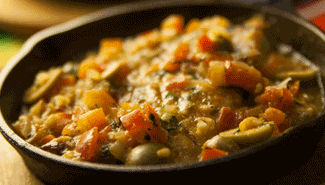 Skillet of stew with tomatoes, olives, and herbs.  best mexican food near me entrees