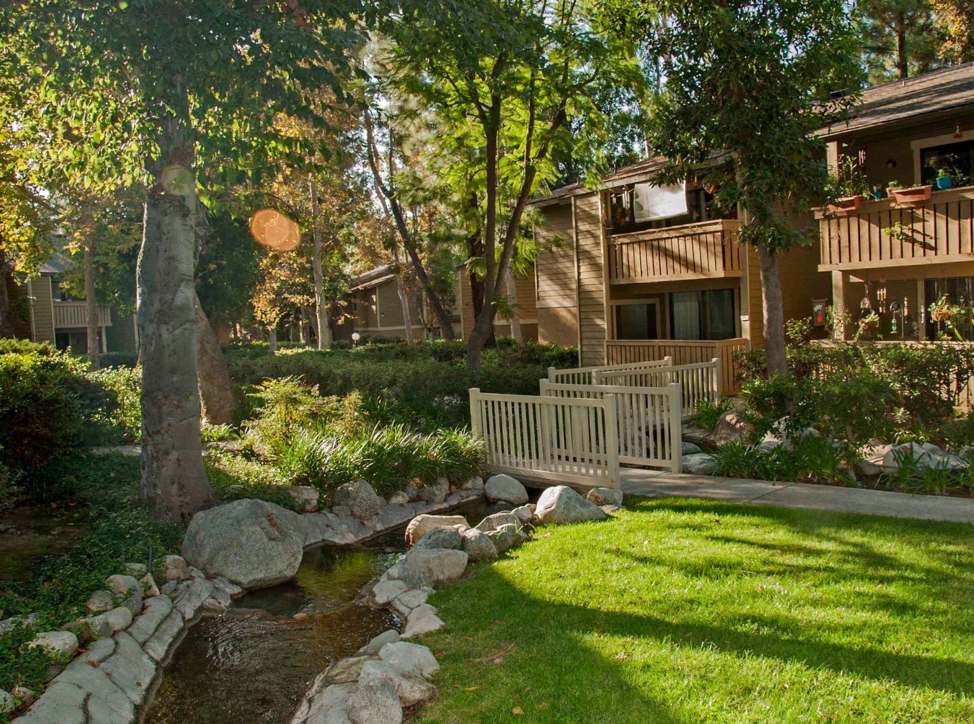 Beautiful landscaping at the property with a small bridge over a stream