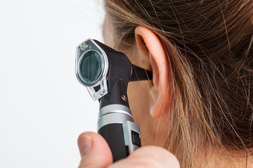 Image of a patient receiving an ear exam with an otoscope