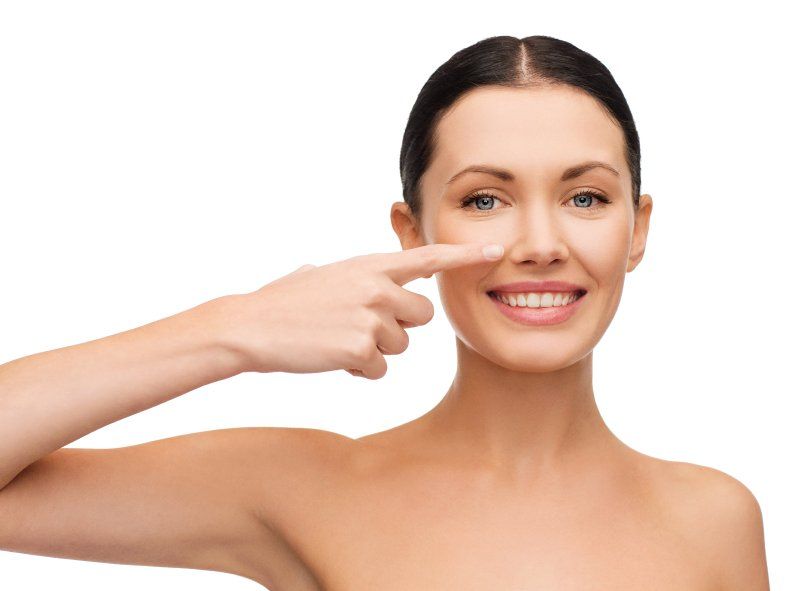 Image of a woman pointing to her nose