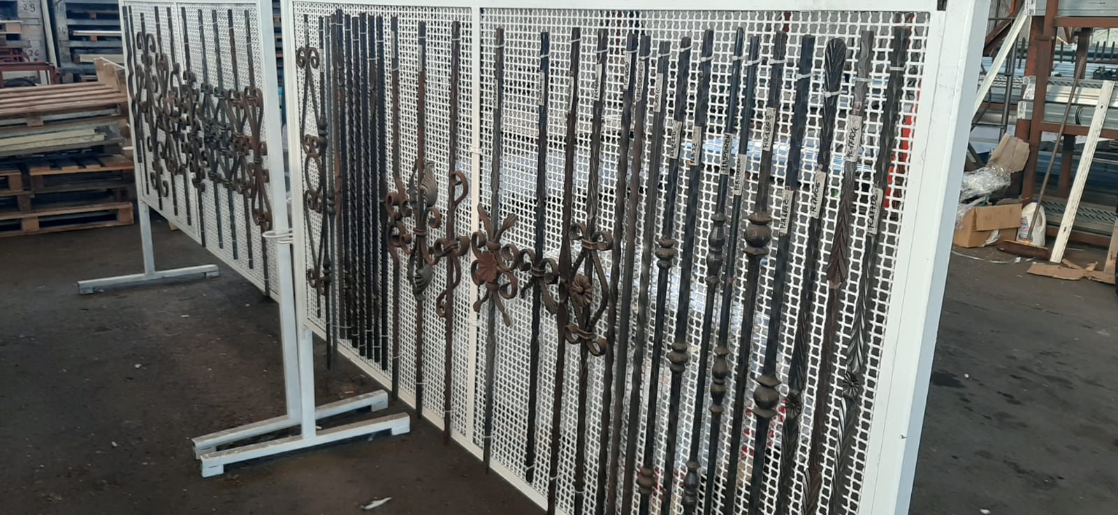 Una fila di recinzioni metalliche una sopra l'altra in un magazzino.