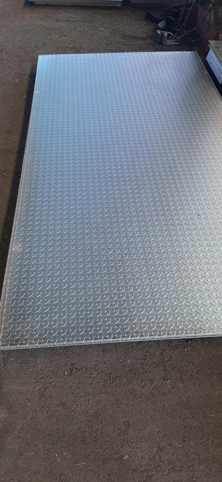 Un grande pezzo di metallo è appoggiato su un pavimento di cemento.