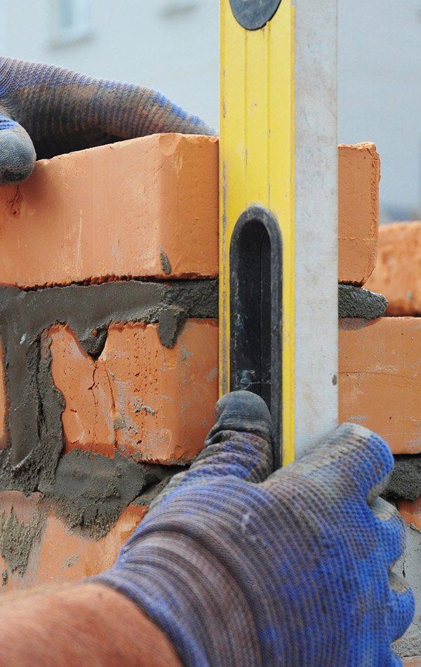 Bricklayer Using A Leveller — New Home Builds in Yeppoon, QLD