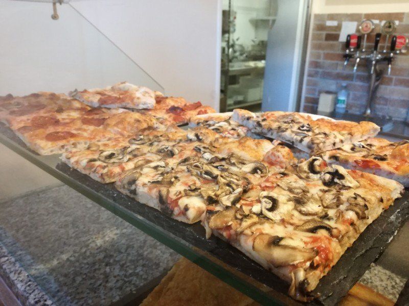 Tagliere di pizza con diversi condimenti