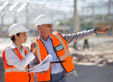 Architects reading blueprints at construction site