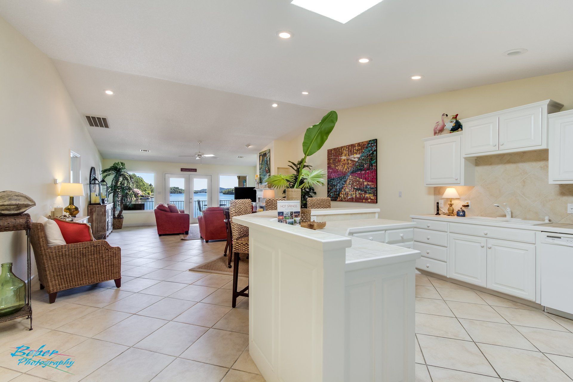 A kitchen with white cabinets and a large island in the middle of the room.