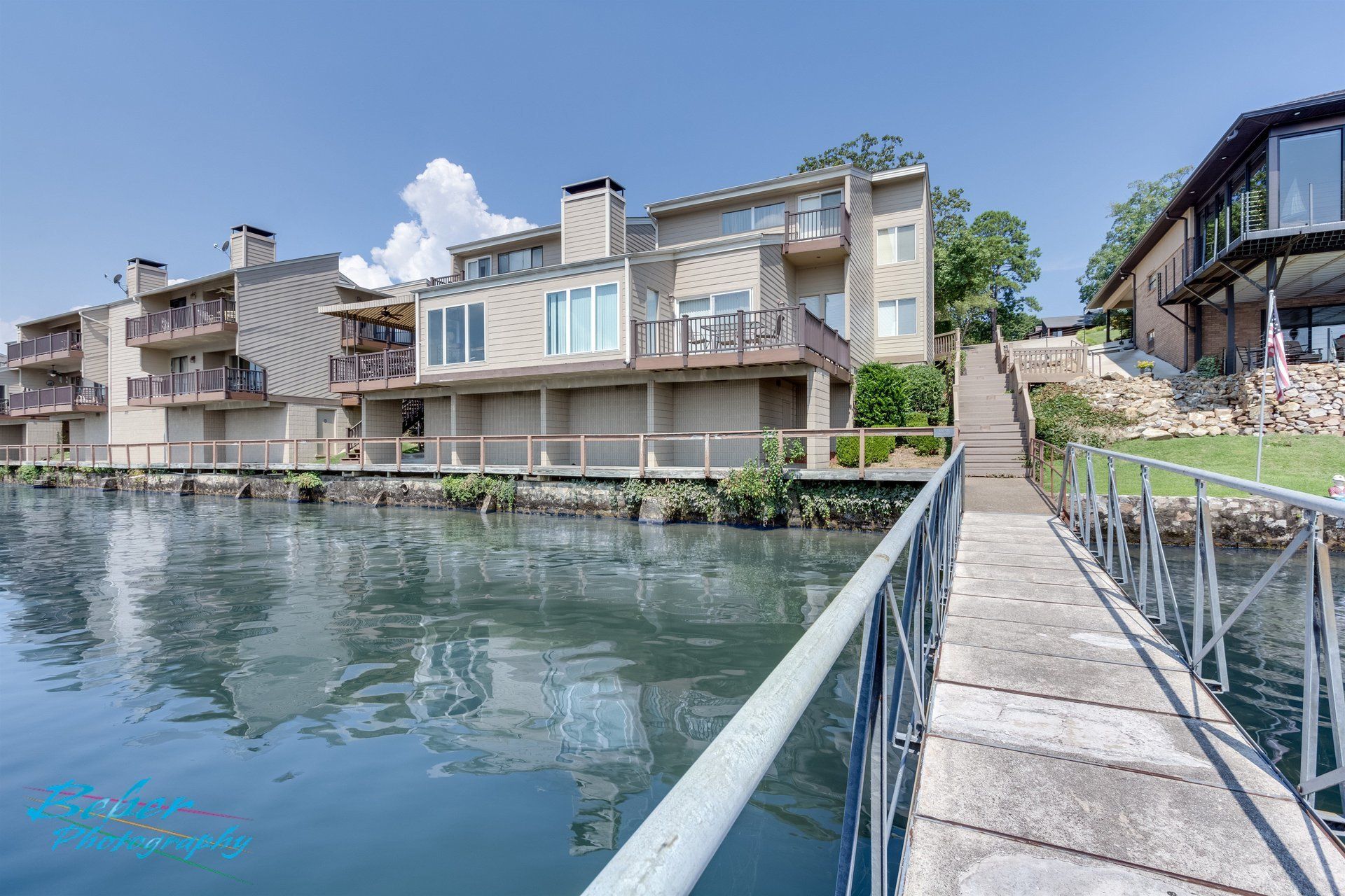 A dock leading to a house next to a body of water.