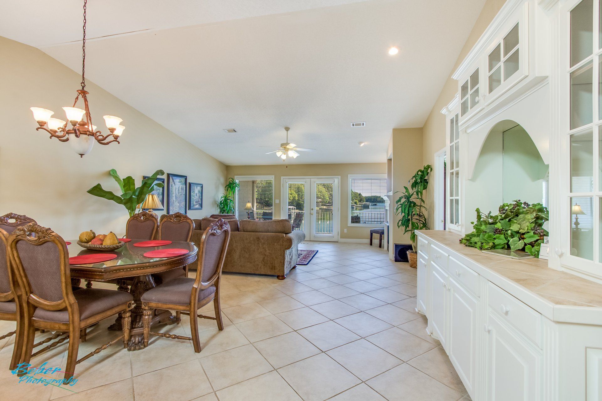 A living room with a dining table and chairs and a chandelier.