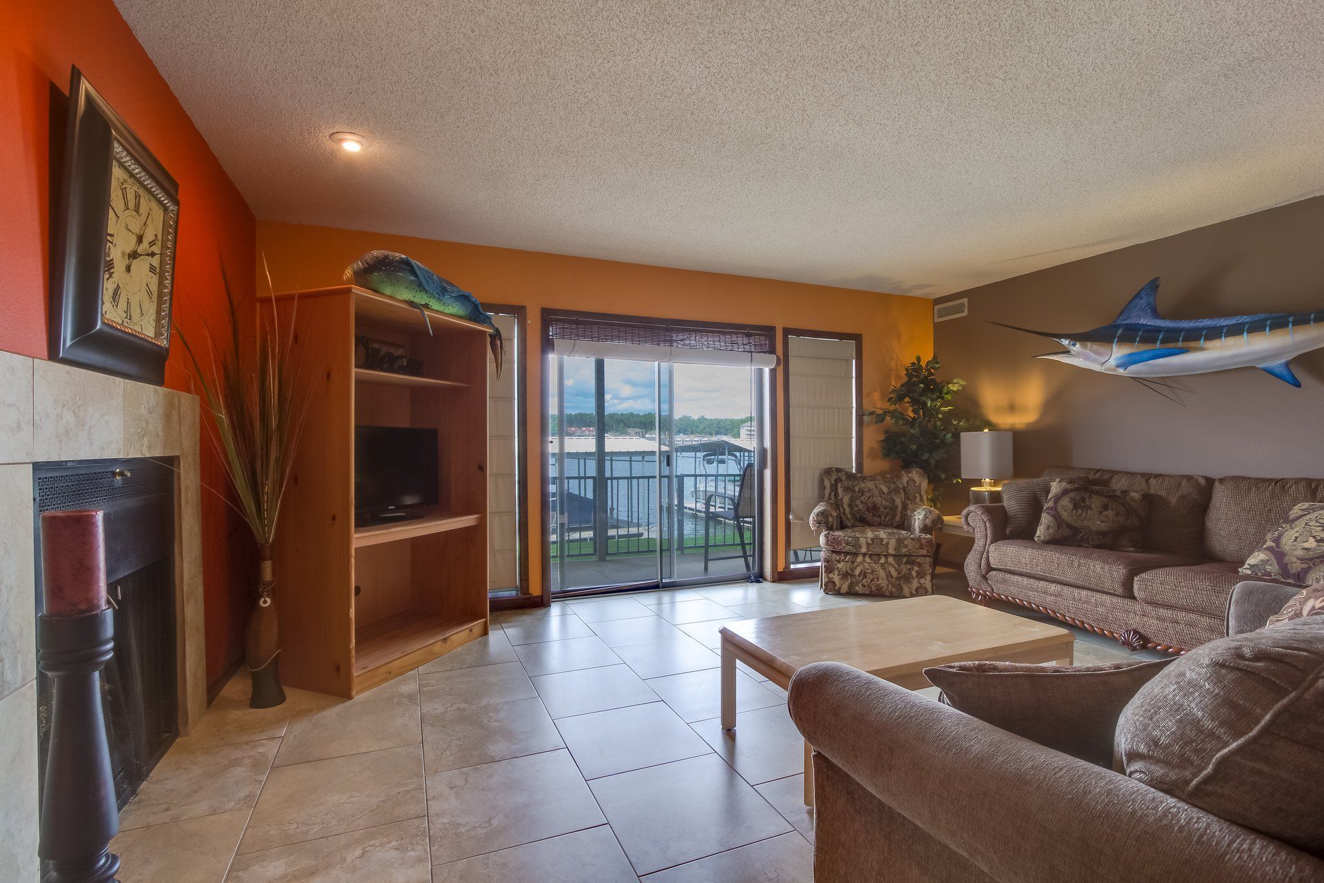A living room with a couch and chairs and a fish on the wall