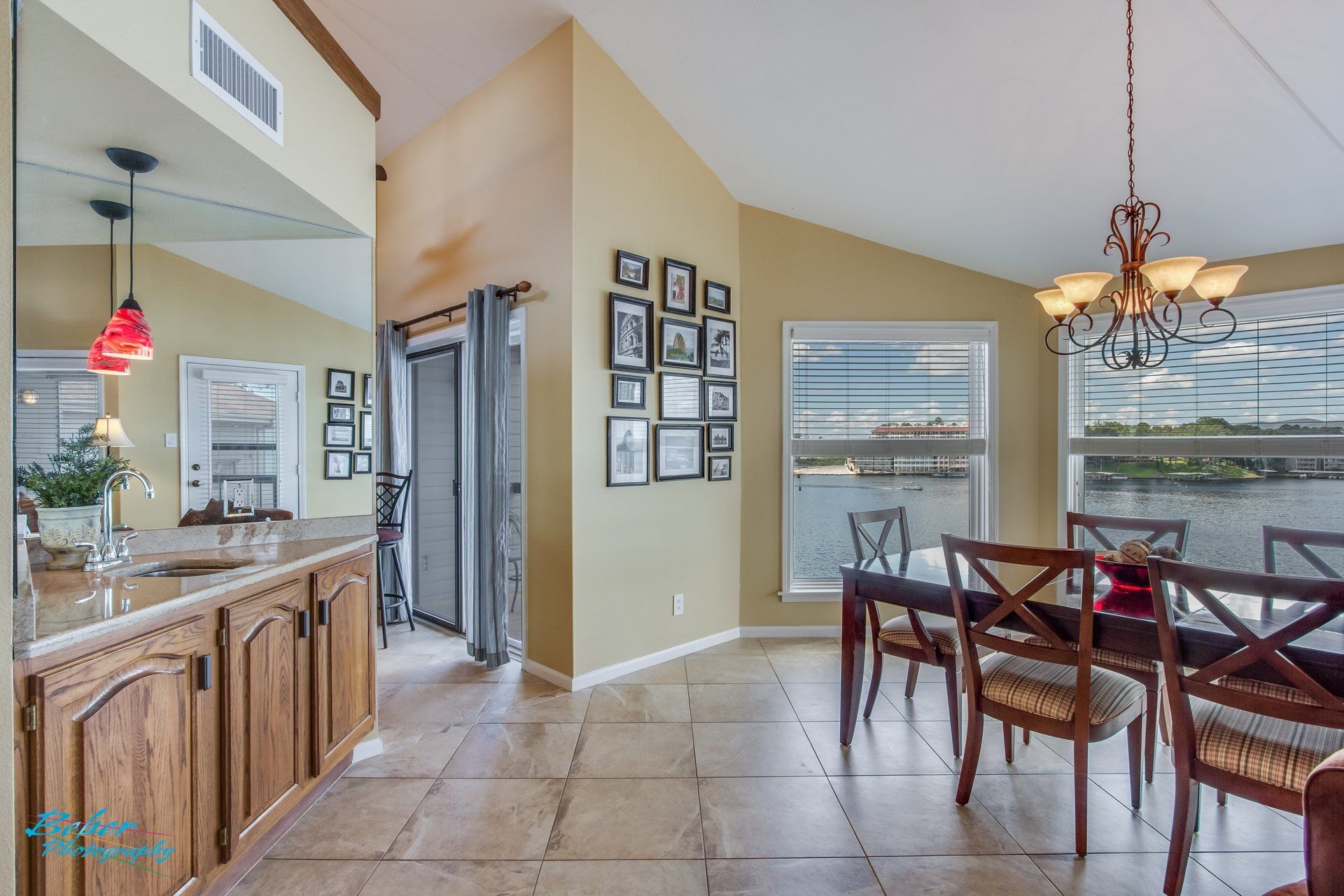 A dining room with a table and chairs and a mirror.