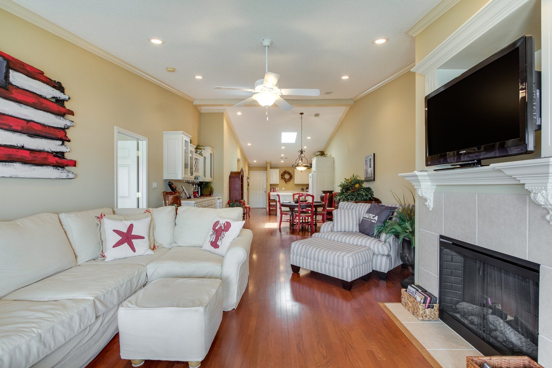 A living room with a couch , chair , fireplace and television.