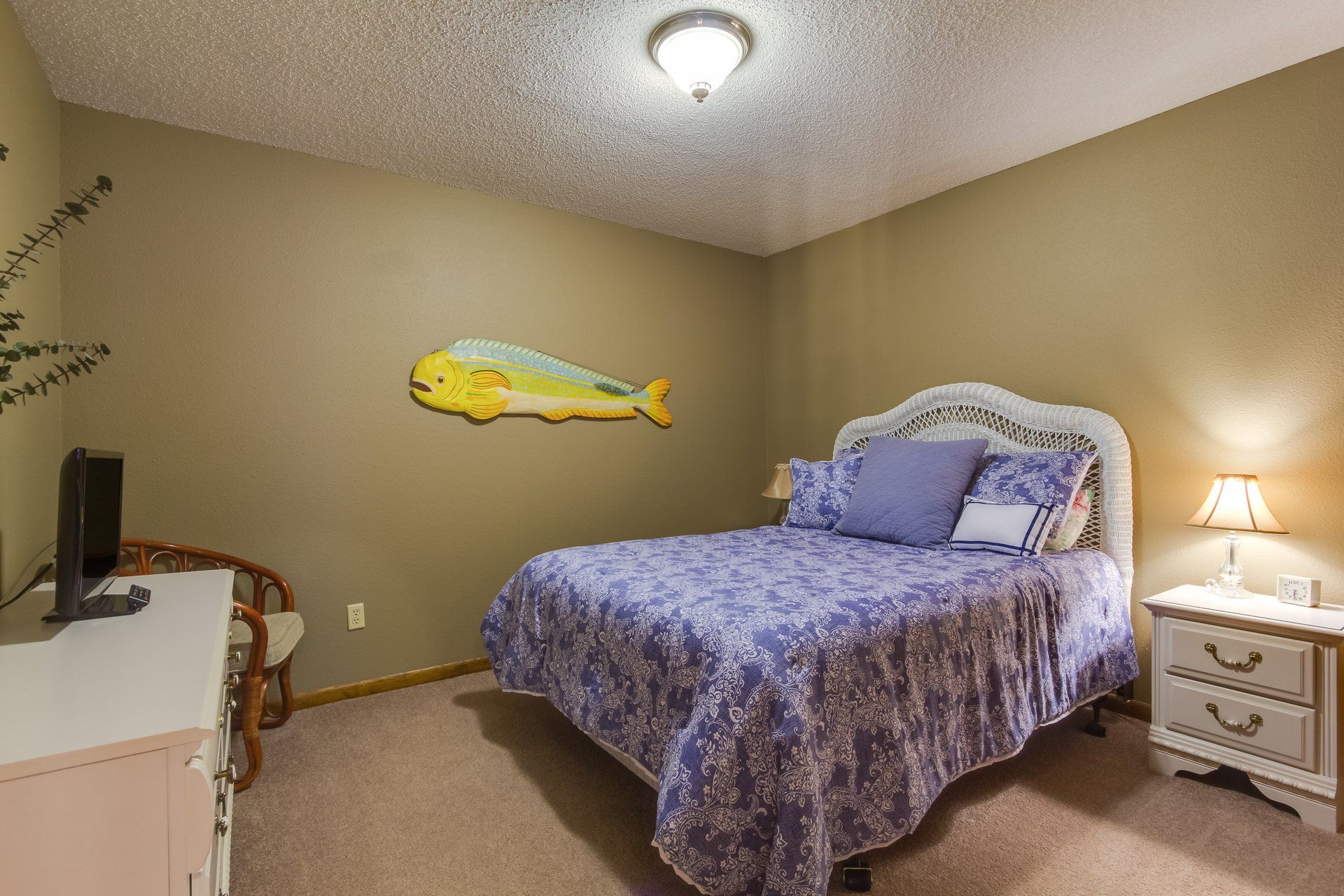 A bedroom with a bed , dresser , nightstand and television.