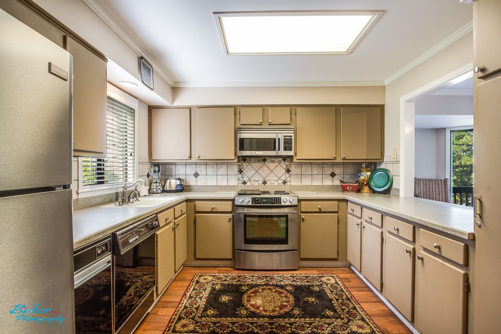 A kitchen with tan cabinets and stainless steel appliances