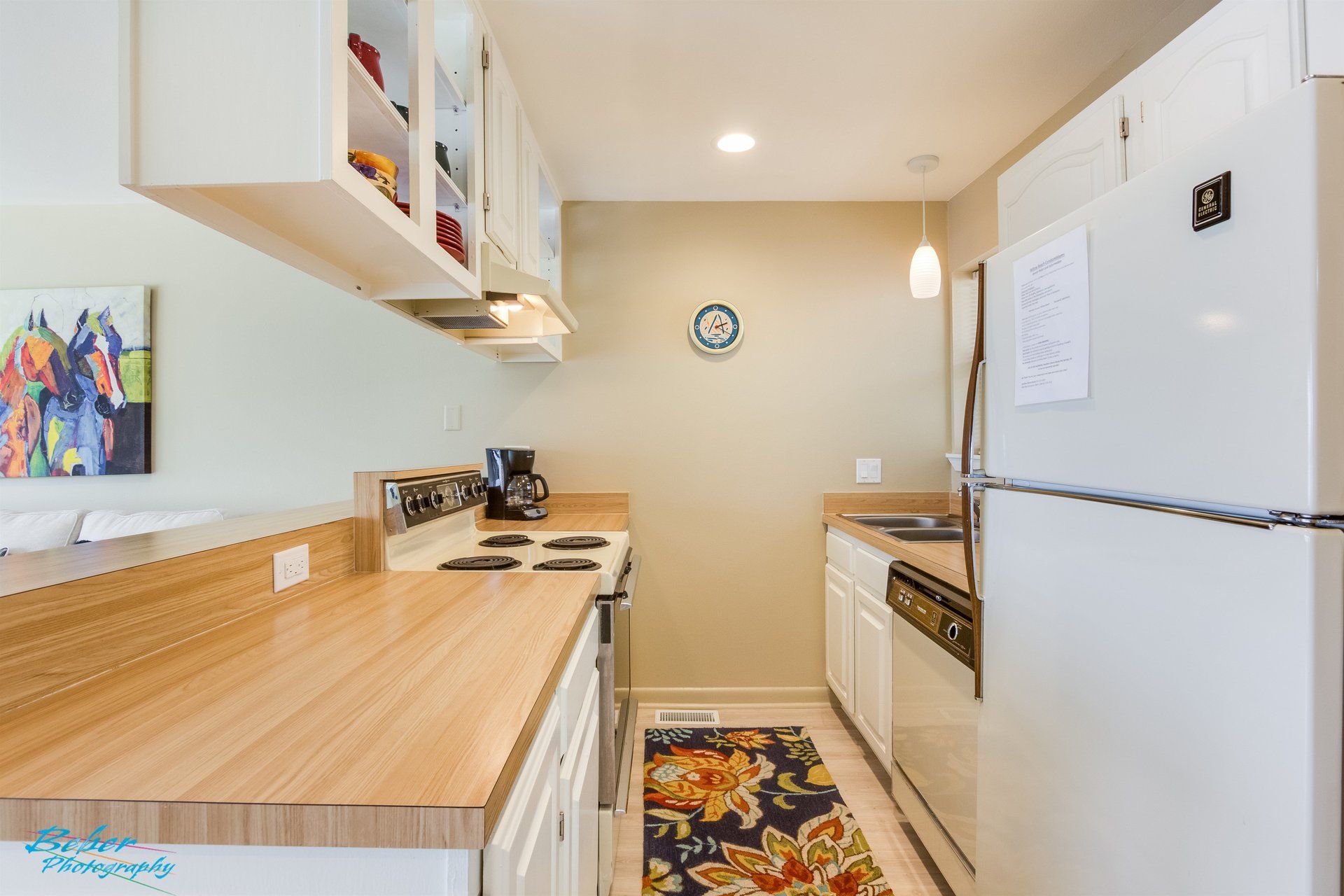 A kitchen with a refrigerator , stove , dishwasher , and sink.