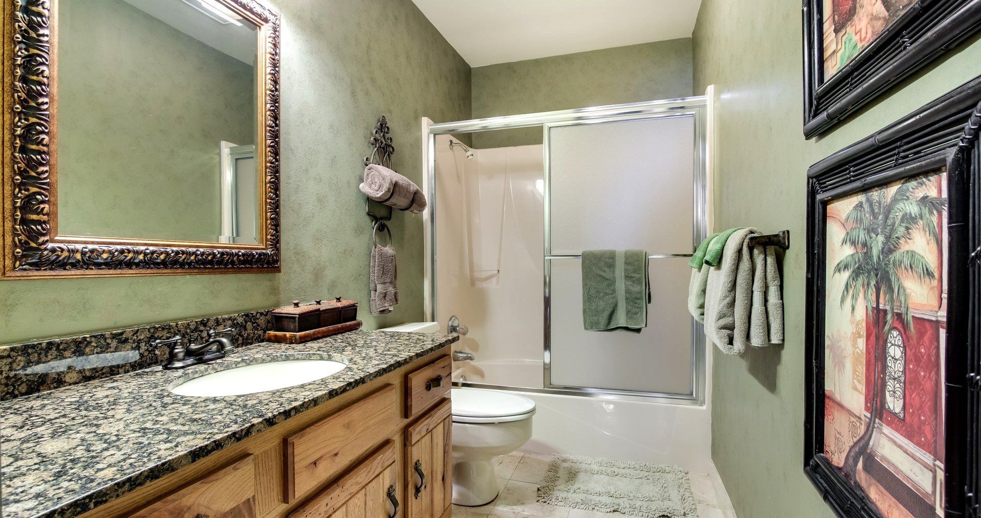A bathroom with a sink , toilet , shower and mirror.