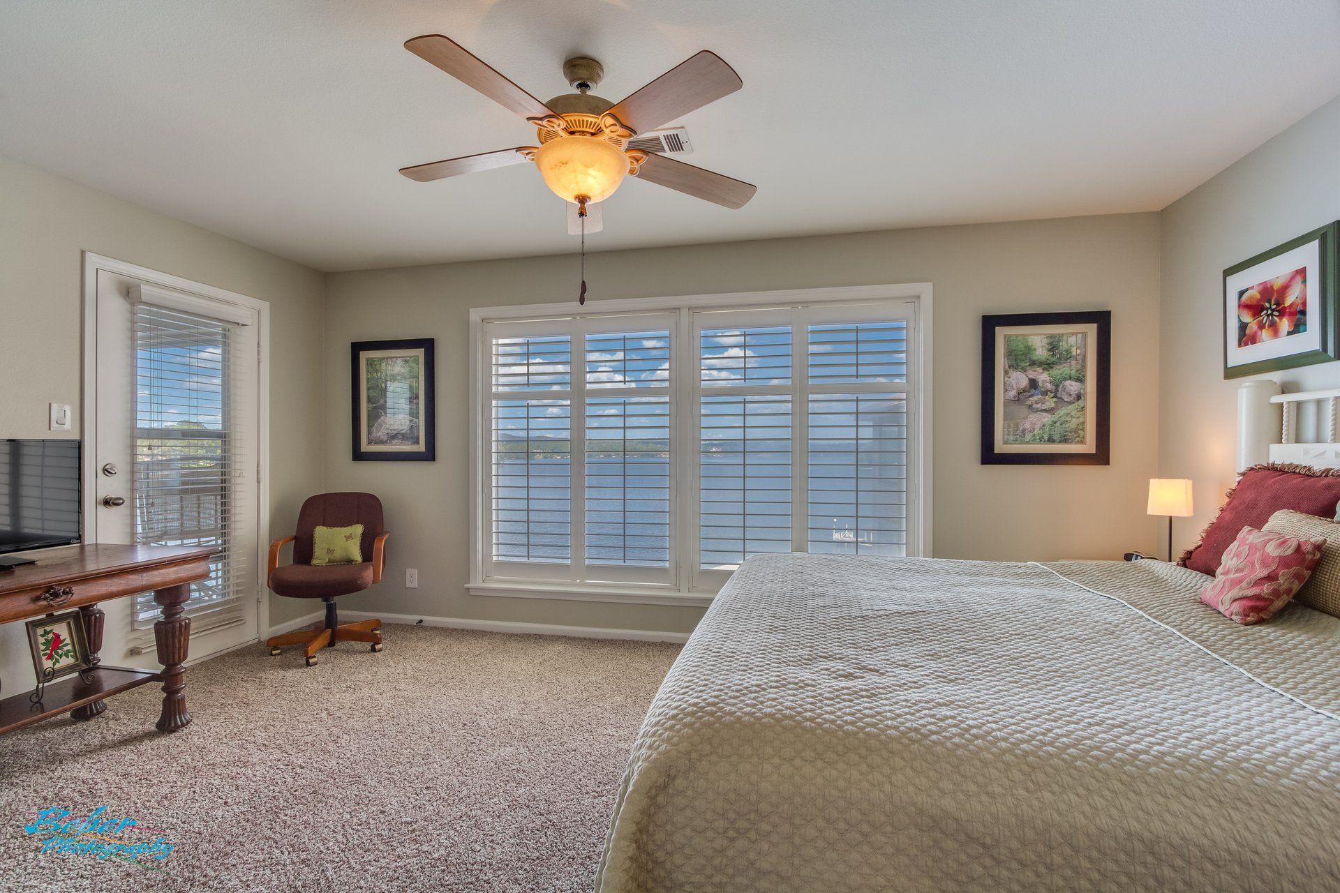 A bedroom with a large bed and a ceiling fan