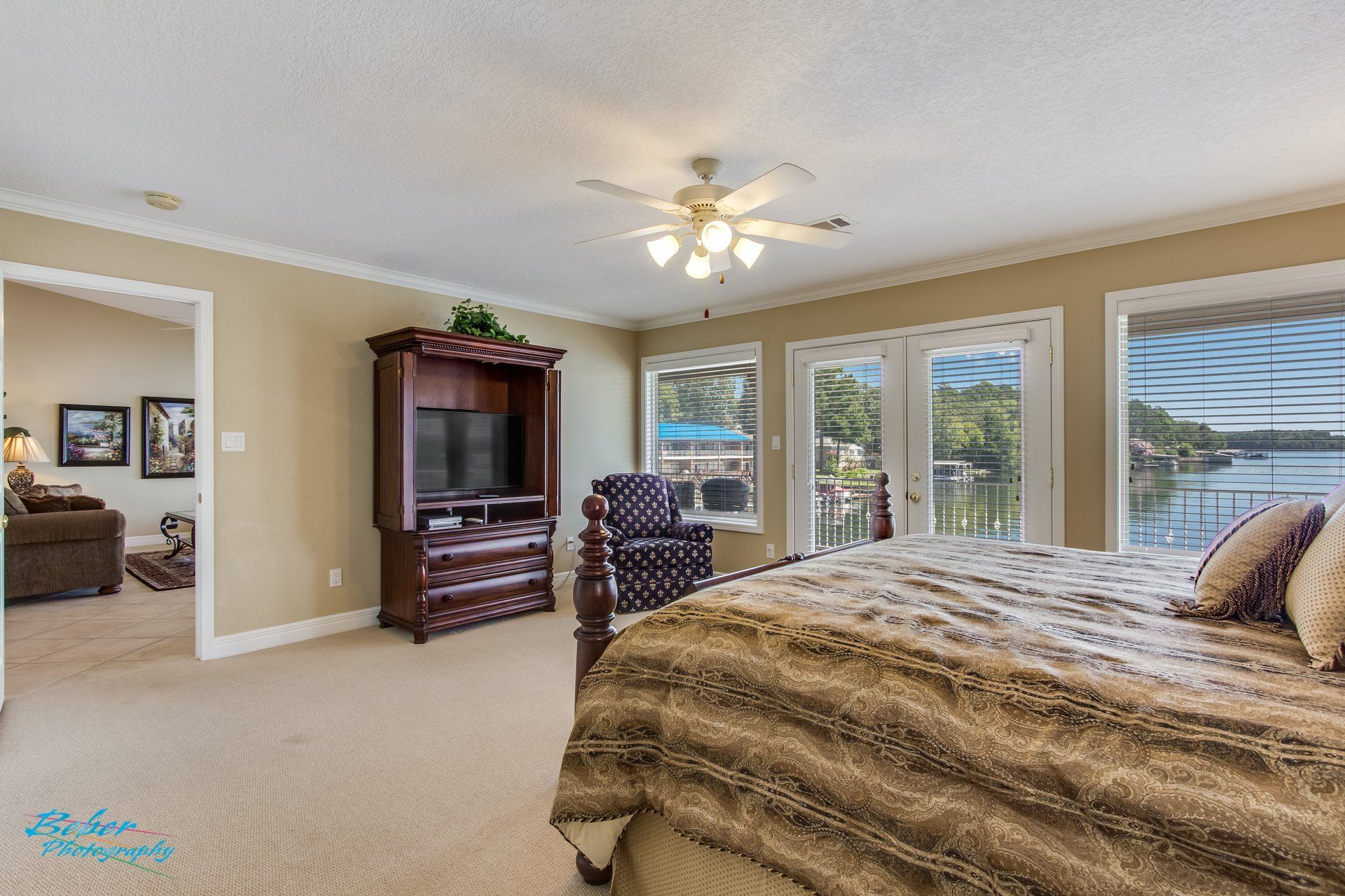 A bedroom with a king size bed , television , dresser and chair.