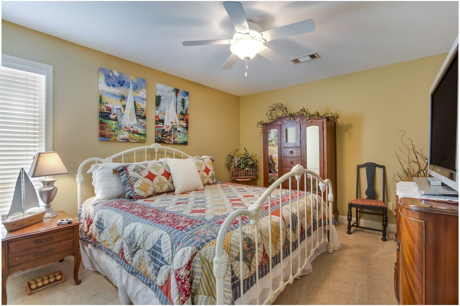 A bedroom with a king size bed and a ceiling fan.