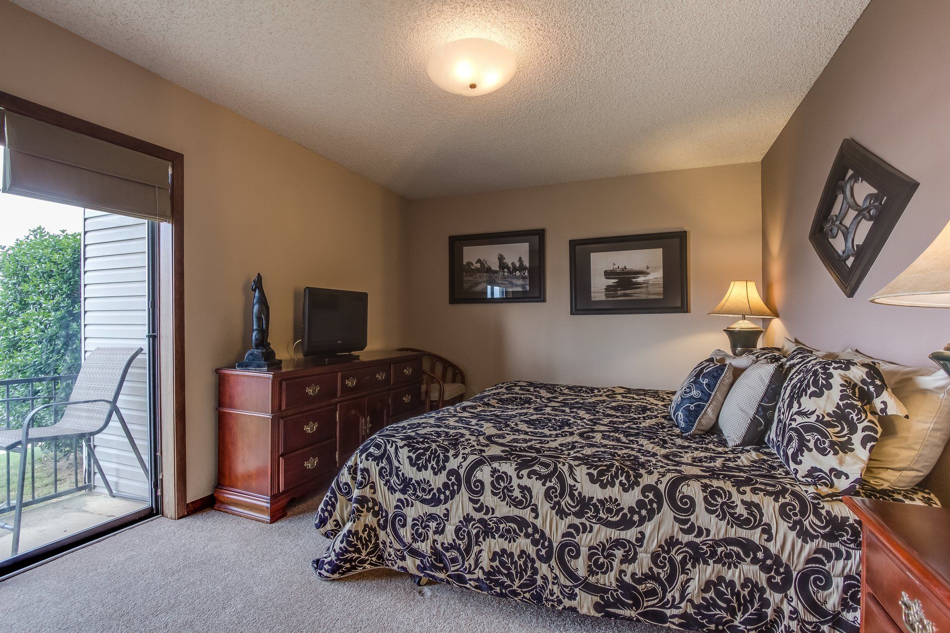 A bedroom with a large bed and a sliding glass door